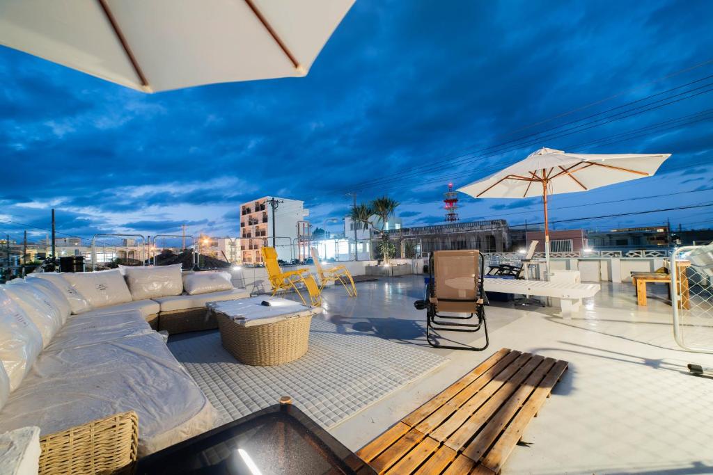 - un toit-terrasse avec un canapé et un parasol dans l'établissement ウエストゲート宮古島, à Île Miyako