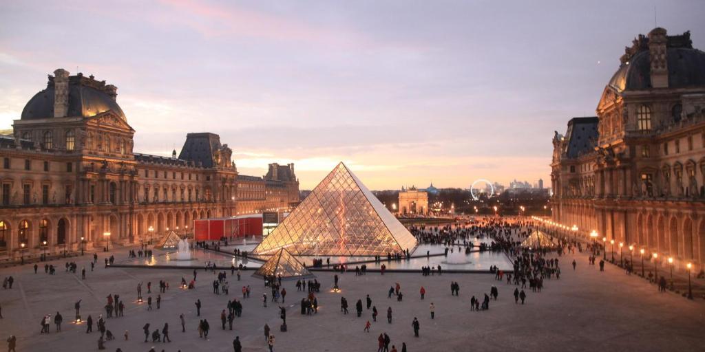 a group of people walking around a city with a pyramid at Chic apart with parking and balcony near Paris in Aubervilliers