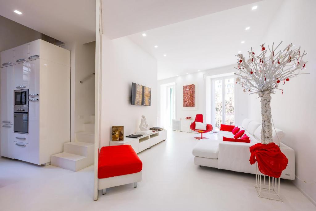 een witte woonkamer met een witte bank en een rode stoel bij Morghen Red Passion and Pop Art in Napels