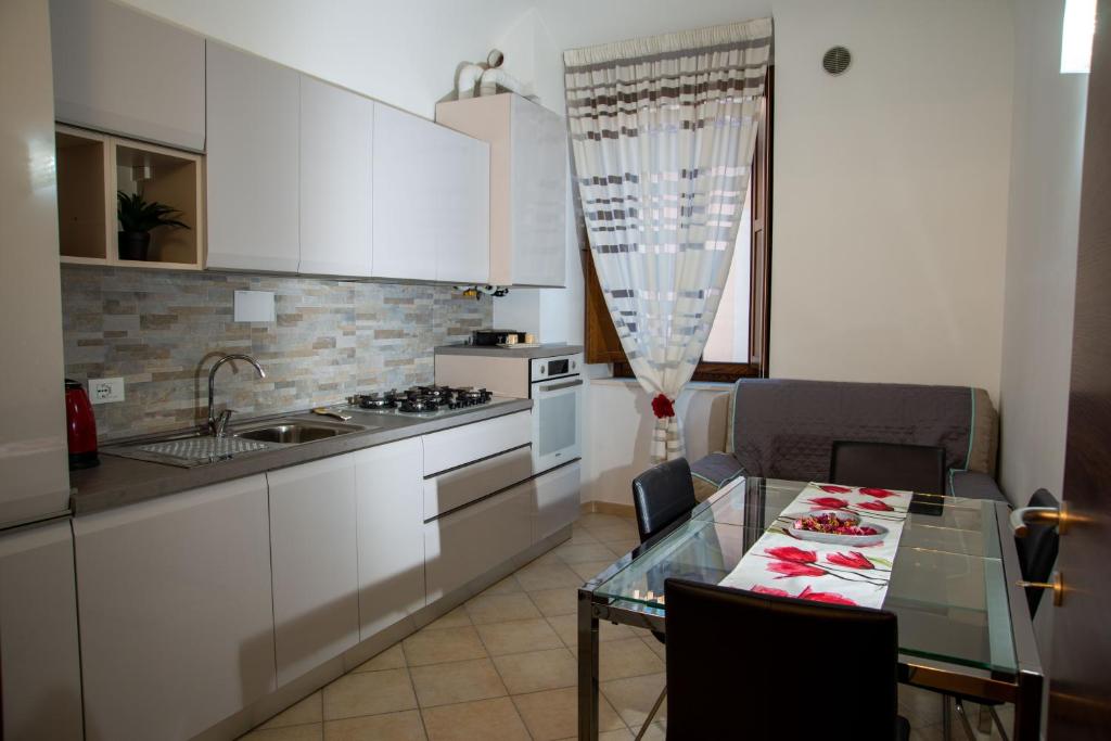 a kitchen with a glass table and a counter top at Casa Fedele in LʼAquila