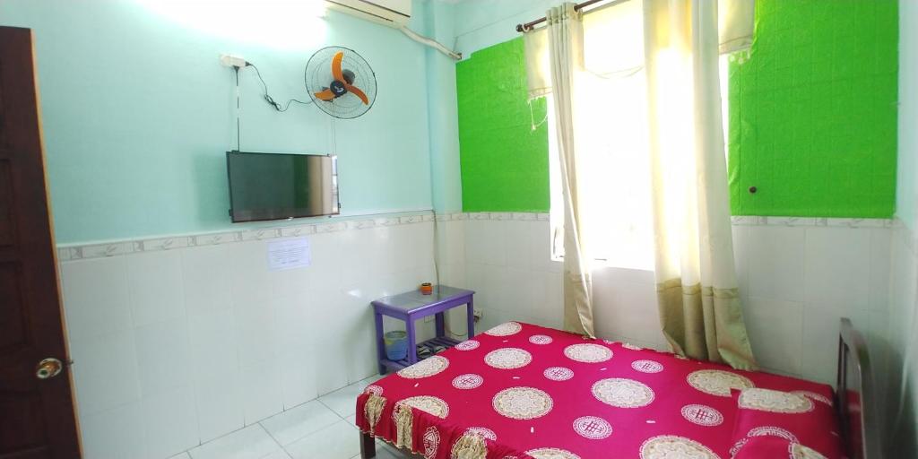a small room with a red bed and a window at Hostel Loc Quyen in Da Nang
