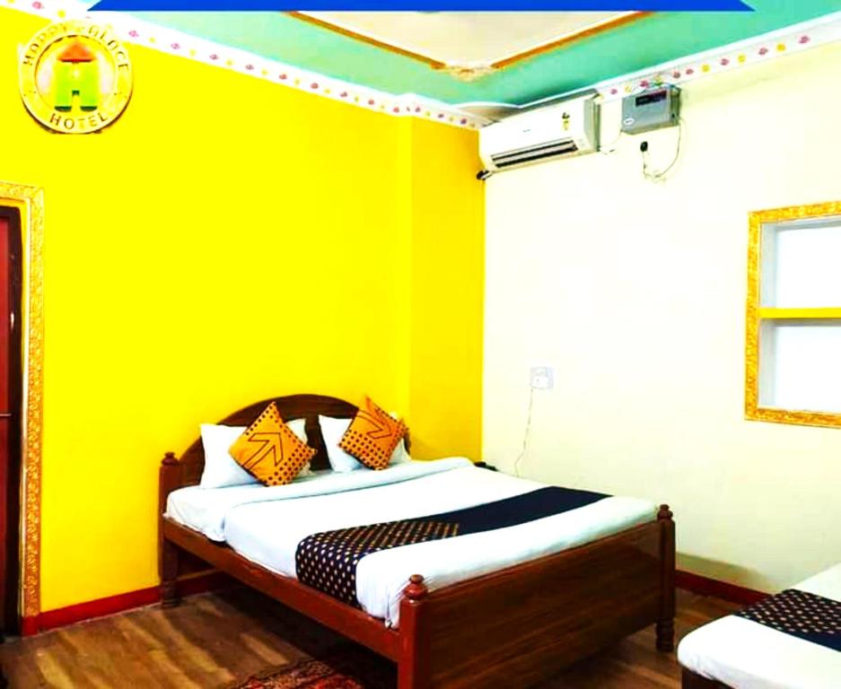a bedroom with a bed with a yellow wall at New Happy palace Inn Gaya Near By Mahabodhi Temple in Gaya