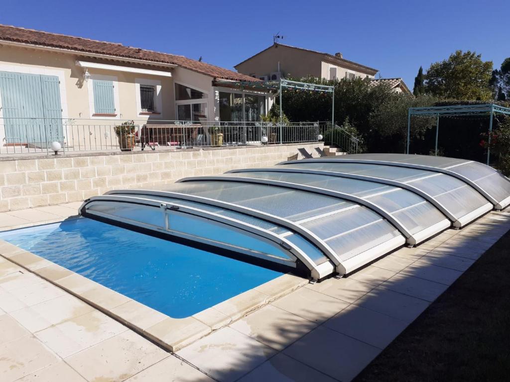 - une piscine avec un couvercle sur le côté d'une maison dans l'établissement Charme au coeur des Alpilles - Villa Le Paradou, à Maussane-les-Alpilles