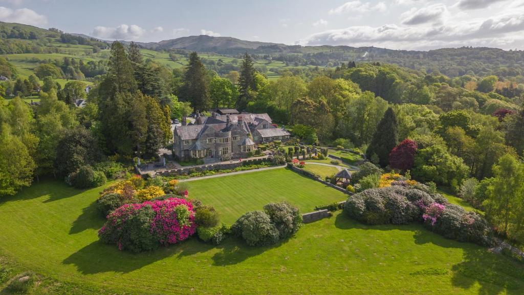 Cragwood Country House Hotel في ويندرمير: اطلالة جوية على بيت كبير في حقل اخضر