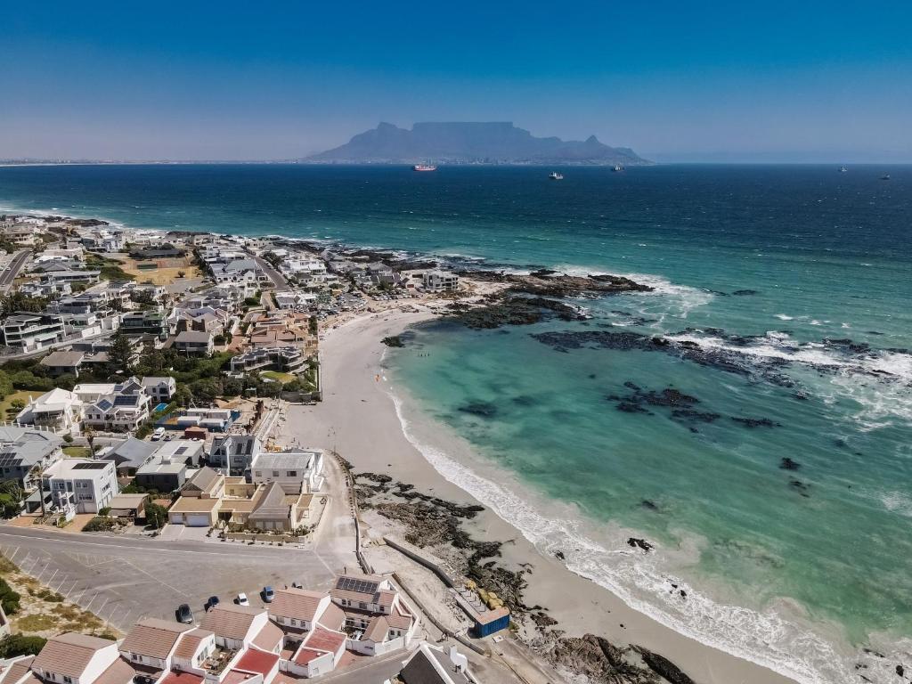 an aerial view of a beach with houses and the ocean at Beachside Cottage in Bloubergstrand