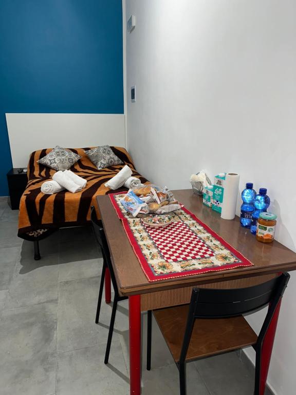 um quarto com uma mesa com uma cama ao fundo em Marrakech rooms 2 em Catânia
