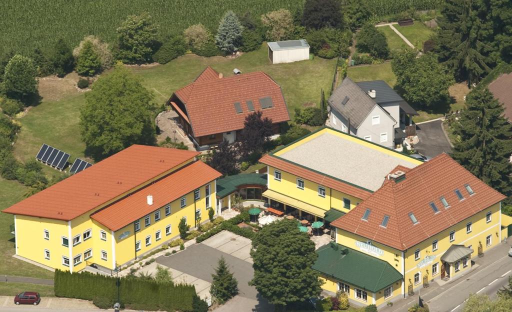una vista aérea de una gran casa amarilla con techos rojos en Hotel Restaurant Neuhold, en Wagna