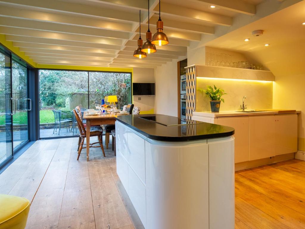an open kitchen with a table and a dining room at Betty's Cottage in Burford