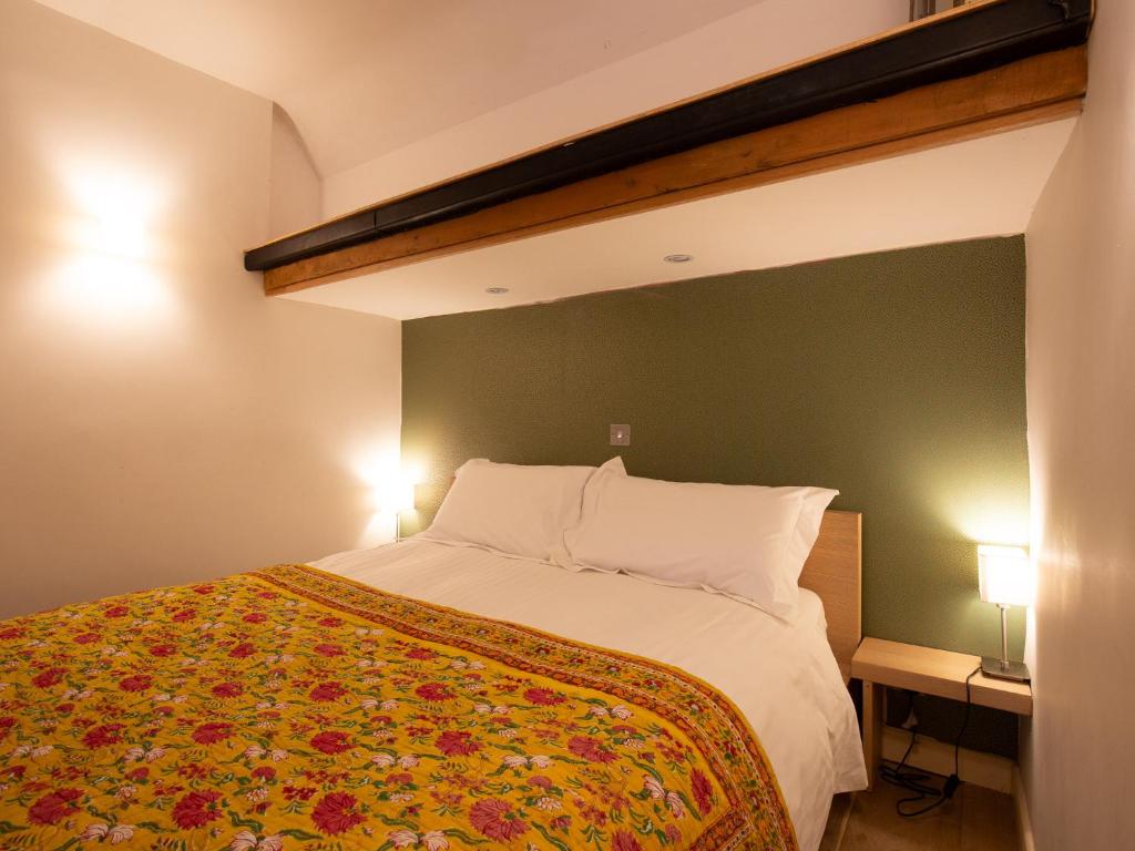 a bedroom with a large bed and two lamps at Betty's Cottage in Burford