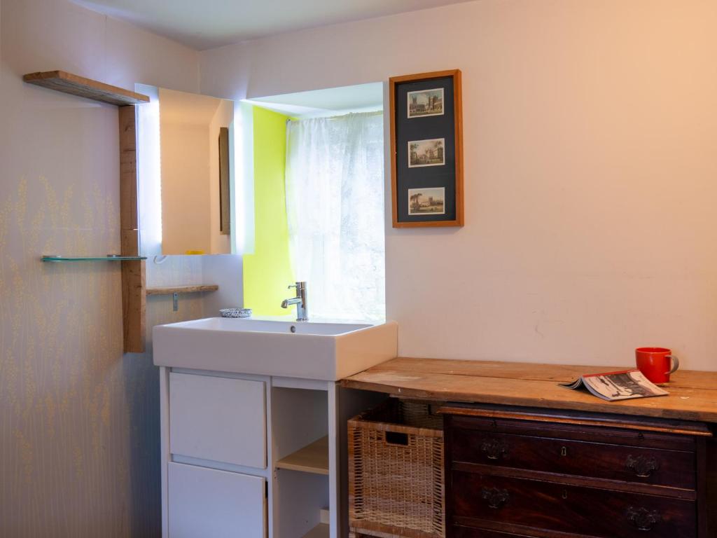 a bathroom with a sink and a mirror at Betty's Cottage in Burford