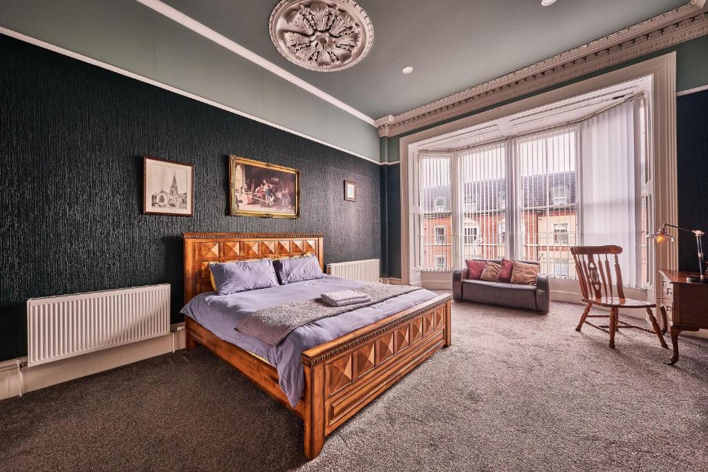 ein Schlafzimmer mit einem Bett und einem Stuhl darin in der Unterkunft 22 The Square in Londonderry County Borough
