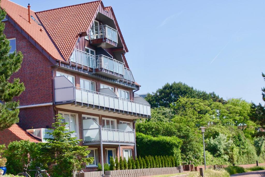 - un bâtiment en briques rouges avec balcon dans l'établissement Strandhaus Rose, à Juist