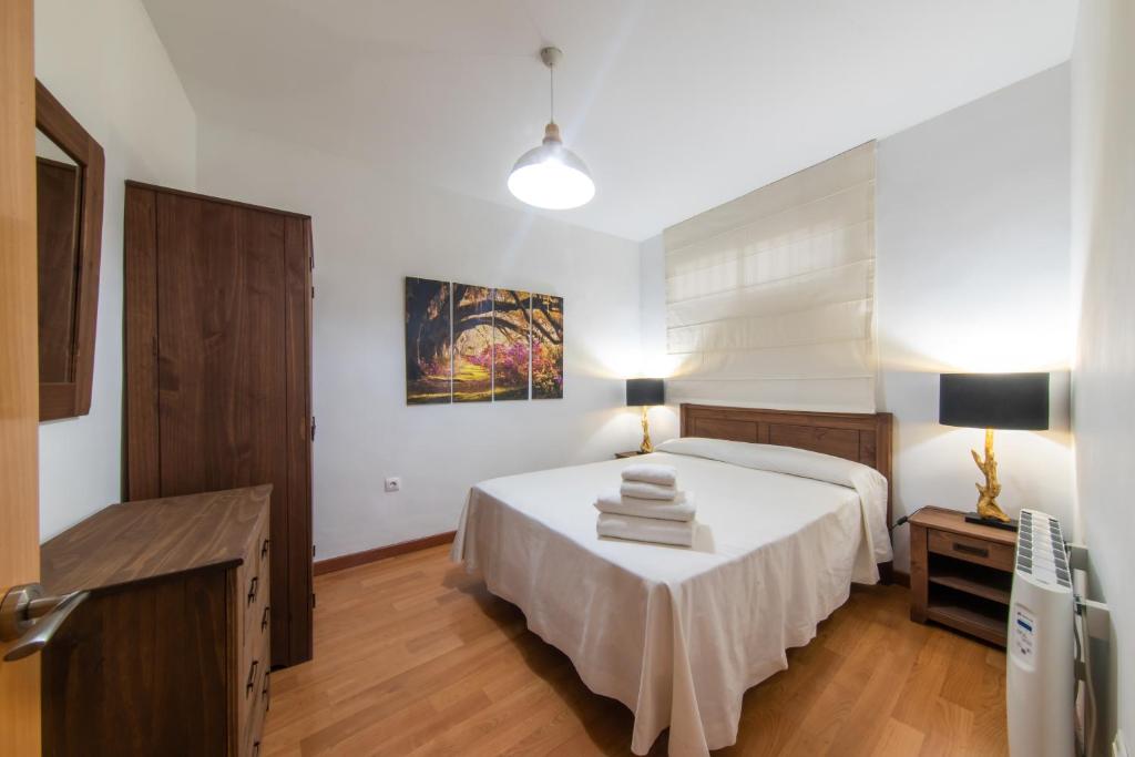 um quarto com uma cama e uma mesa com toalhas em Apartamentos Moon Dreams Puerto em El Puerto de Santa Maria