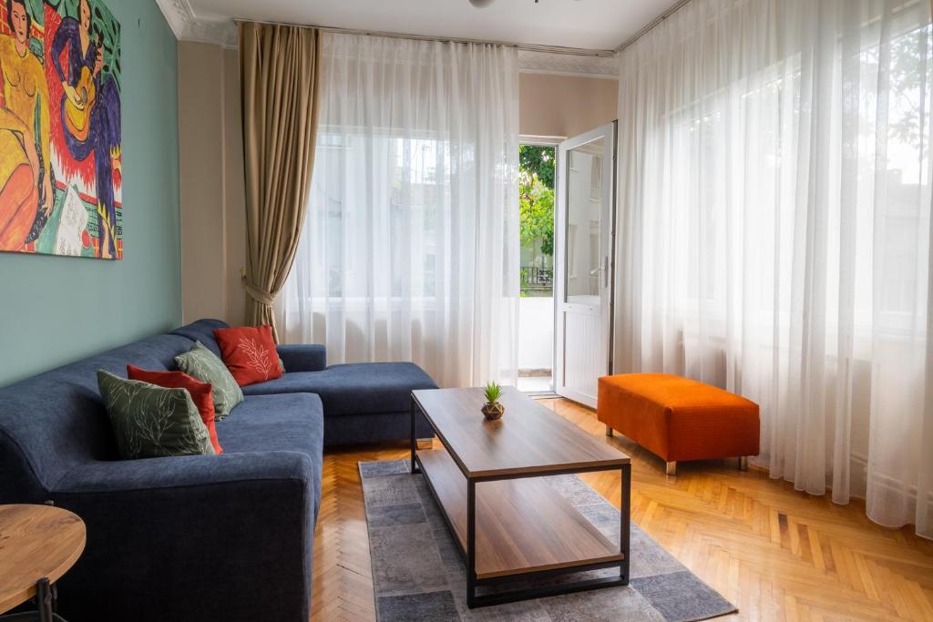 a living room with a blue couch and a table at Fully Equipped & Modern Designed Spectacular 3BR in Istanbul