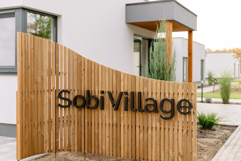 a fence in front of a house with the word sod village on it at Sobi Village in Oseshchino