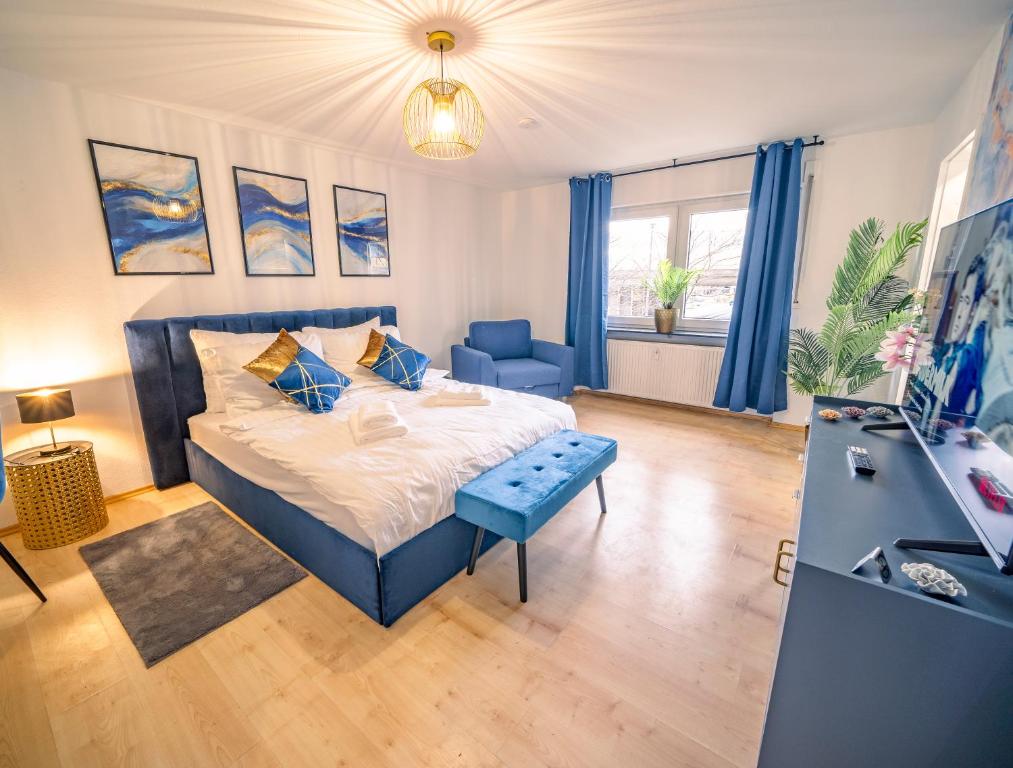 een slaapkamer met een blauw bed en een blauwe stoel bij City Heart - 2min to station in Ludwigshafen am Rhein