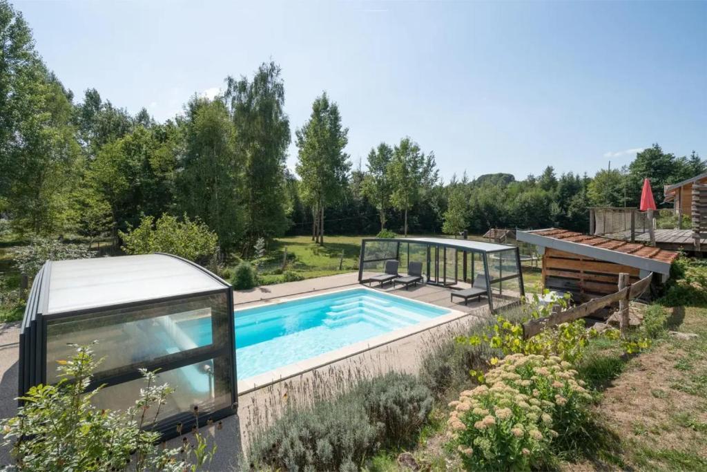 una piscina en un jardín con una casa en Piscine Jacuzzi Sauna 4 étoiles, en Uzemain