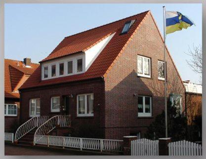 una casa con una bandera volando delante de ella en Haus Monika, en Juist