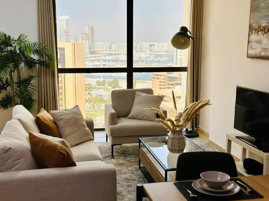 a living room with two couches and a large window at Vacation Home In Best Part of Dubai in Dubai