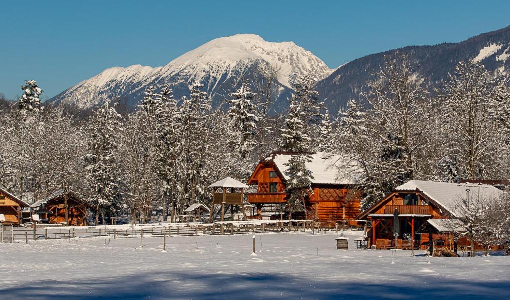 a snow covered mountain in front of a lodge at Ranč Mackadam Ranch Mackadam in Tržič