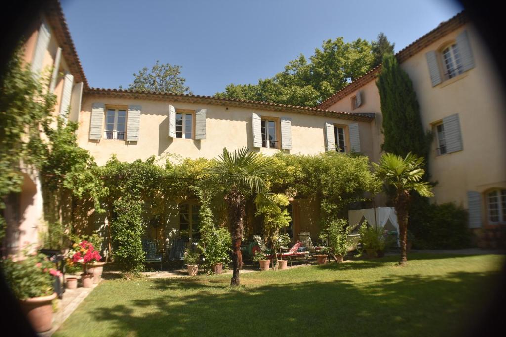 ein großes Haus mit Bäumen und Pflanzen im Hof in der Unterkunft Bastide Complète à Aix in Aix-en-Provence
