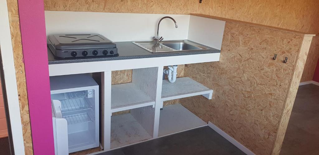 uma pequena cozinha com um lavatório e um fogão em Huisje de Bosrand em Bant