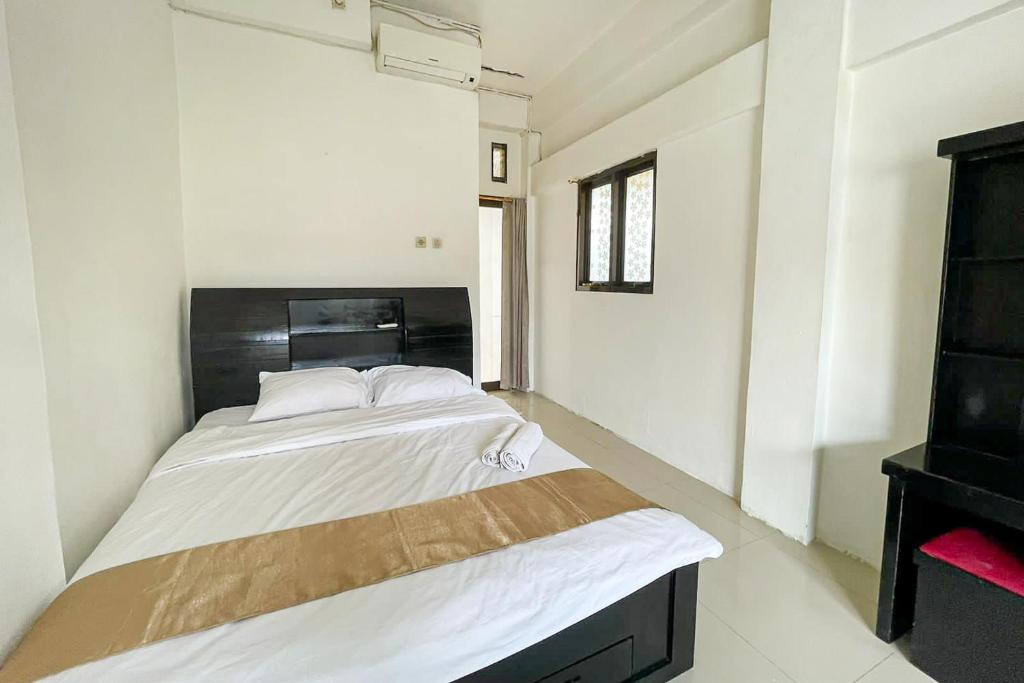 Salsabila Villa Syariah RedPartner في Kedemangan-wetan: غرفة نوم بسريرين وخزانة
