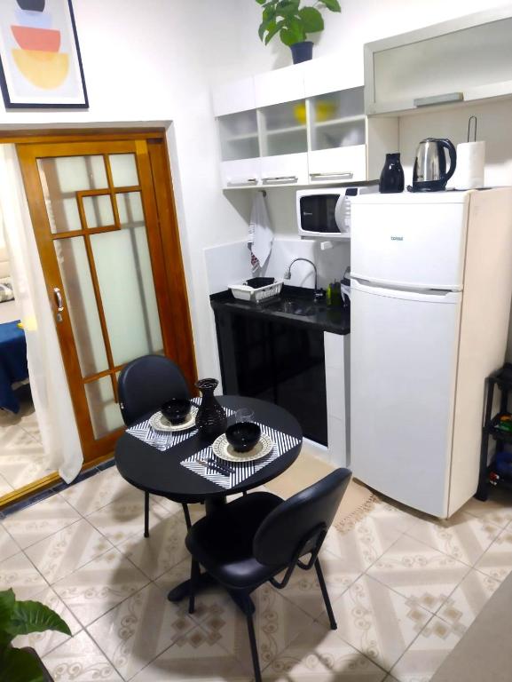 a kitchen with a table and chairs and a refrigerator at Flat Duplo para sua conexão in Guarulhos