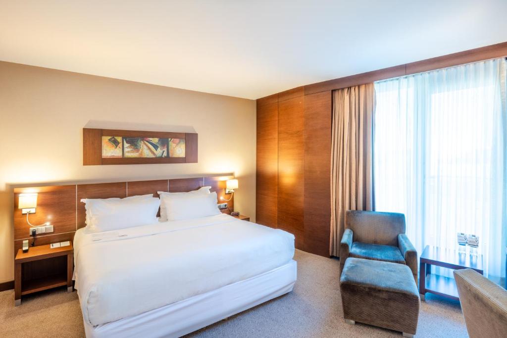 a hotel room with a bed and a chair at FLY INN BAKU in Baku