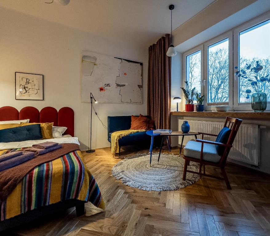 a bedroom with a bed and a table and a chair at Tranquil Old Town Retreat in Warsaw