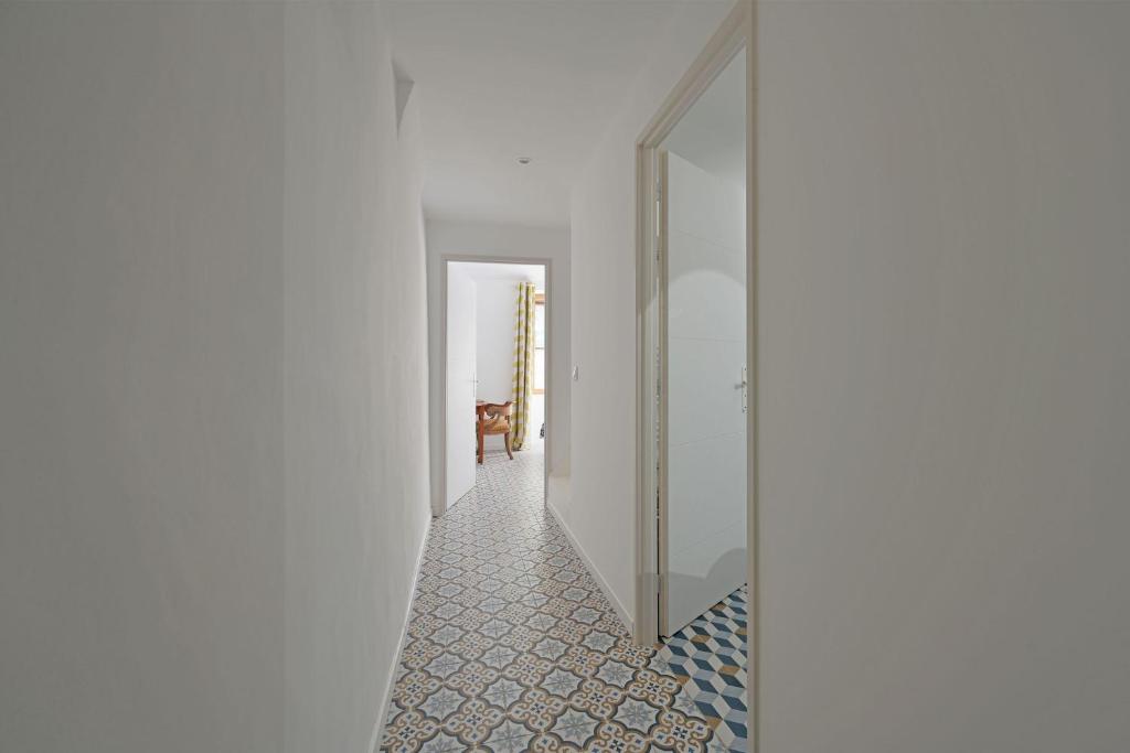 a hallway with white walls and a mirror at La Cigale - Vieux Village - Charmante Maisonnette climatisée avec Jardin in Villeneuve-lès-Avignon
