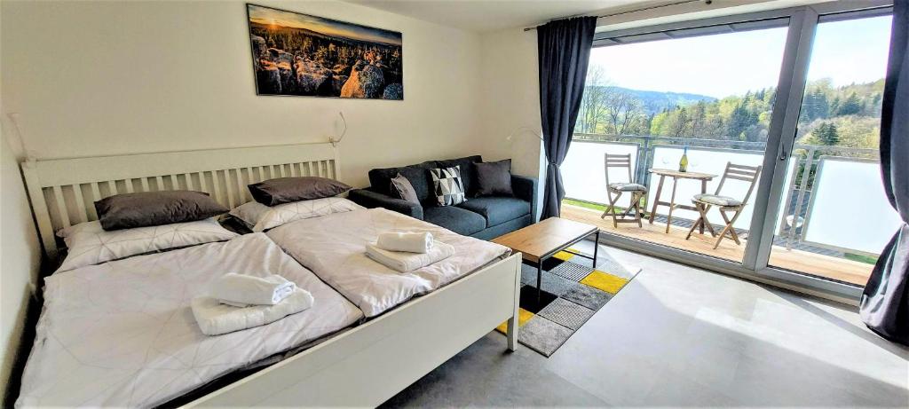 a bedroom with a large bed and a large window at Apartmán Na kraji lesa in Janov nad Nisou
