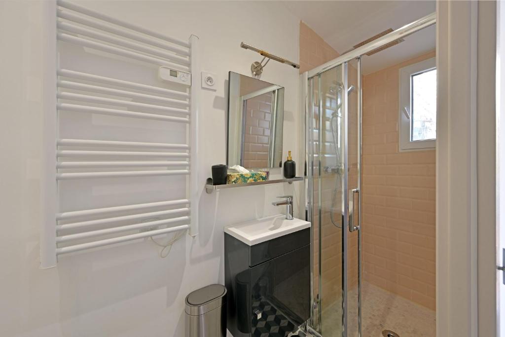 a white bathroom with a sink and a shower at La Cigale - Vieux Village - Charmante Maisonnette climatisée avec Jardin in Villeneuve-lès-Avignon