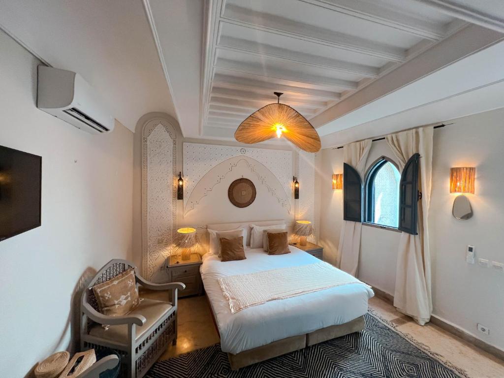 - une chambre avec un lit et une chaise dans l'établissement Riad Jonan & Spa, à Marrakech