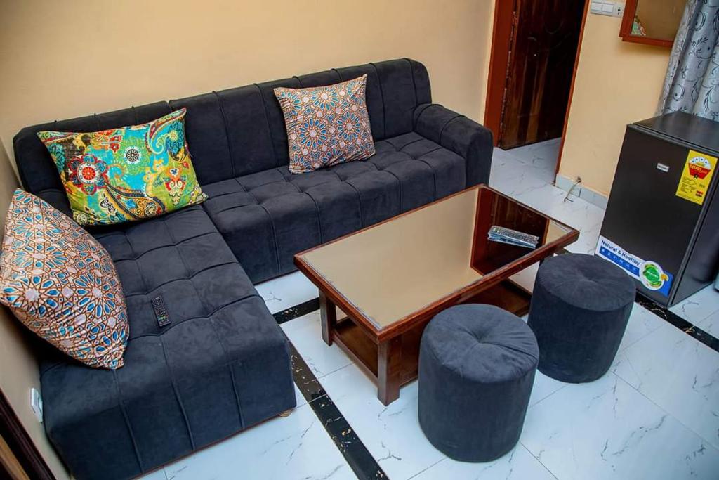 瓦加杜古的住宿－Sawadogo meublée，客厅配有沙发、桌子和凳子
