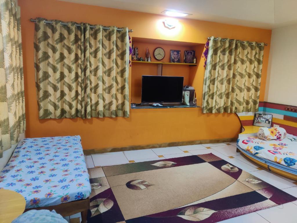 a living room with a tv and a couch and a table at Holiday Staycation Vilha in Nashik