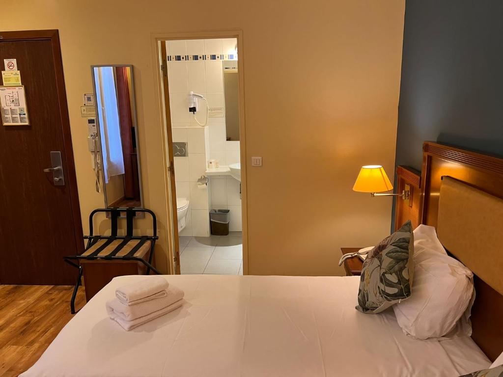 a bedroom with a bed and a bathroom at 121 Paris Hotel in Paris