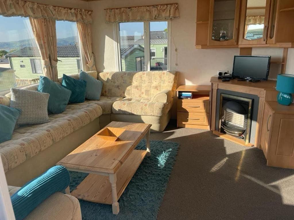 a living room with a couch and a tv at 2 bedroom cosy caravan in Borth