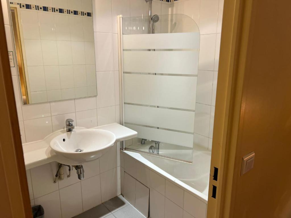a white bathroom with a sink and a shower at 121 Paris Hotel in Paris