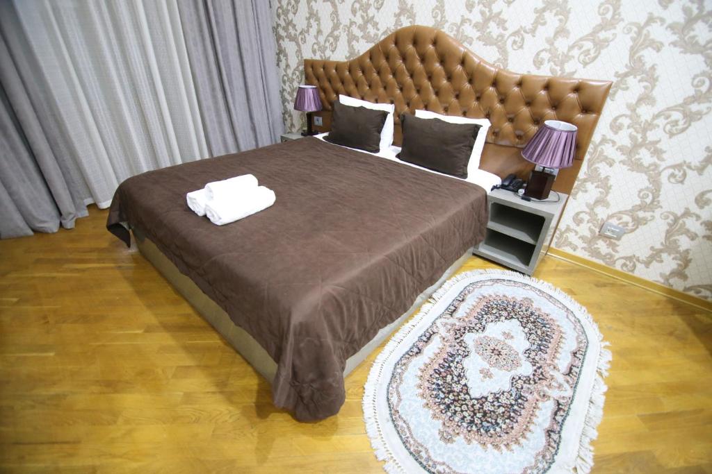 a bedroom with a large bed with a large headboard at Prime Hotel in Baku