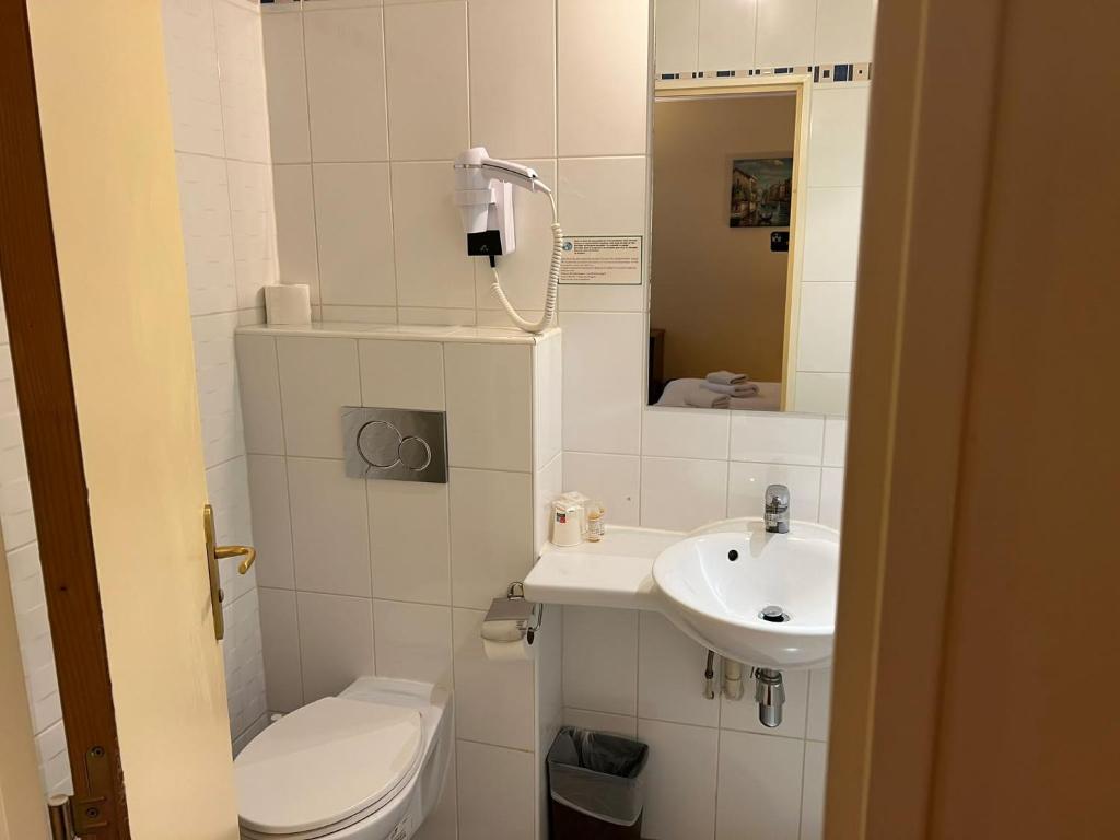 a small bathroom with a toilet and a sink at 121 Paris Hotel in Paris