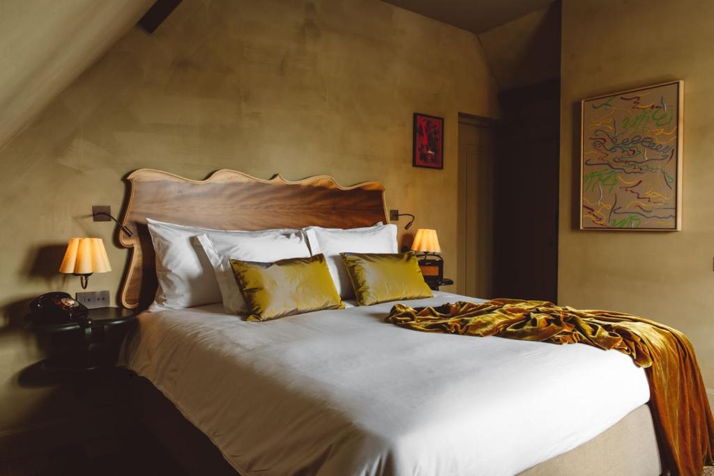 una camera da letto con un letto con lenzuola bianche e cuscini gialli di De Durgerdam, Amsterdam ad Amsterdam