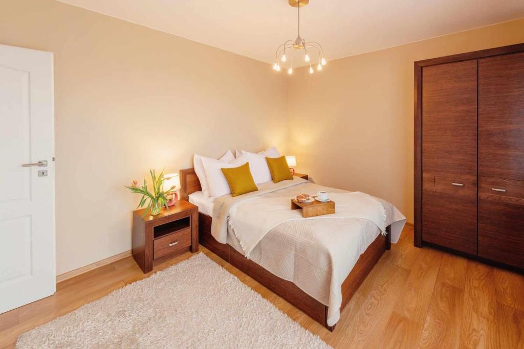 a bedroom with a large bed with a nightstand and a bed sidx sidx sidx at Apartamenty Straconka 3,Bielsko-Biala in Bielsko-Biała