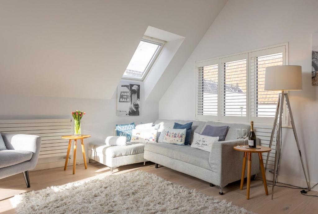 a living room with a couch and a chair at Sandy Castle in Southwold