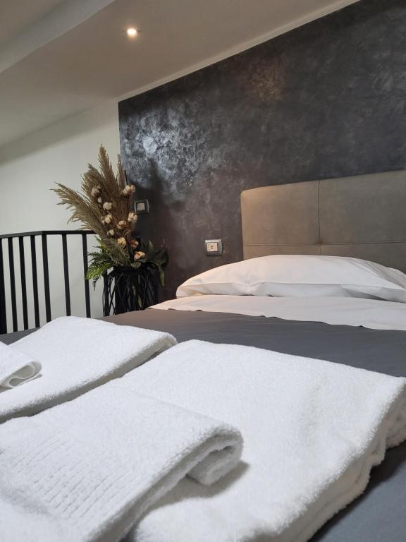 1 dormitorio con 2 camas y toallas blancas. en La bomboniera di Dante, en Nápoles