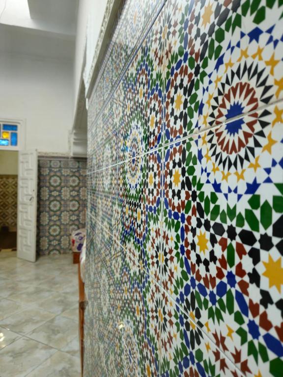 uma parede coberta de mosaicos coloridos num quarto em Dar Ba sidi em Rabat