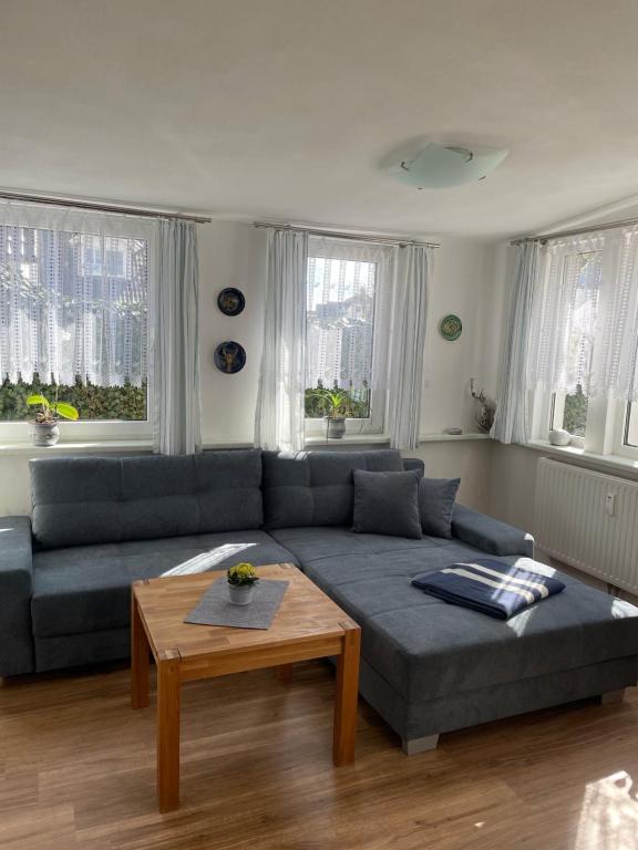 a living room with a blue couch and a table at Meyers Veranda in Zingst