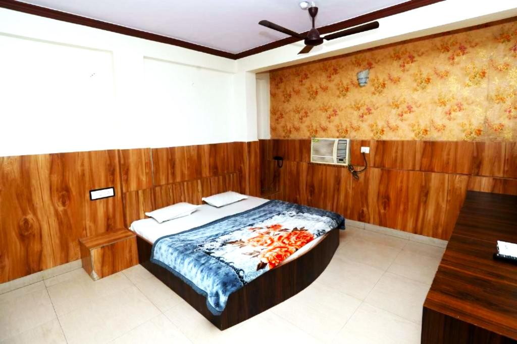 a bedroom with a bed with a wooden wall at Hotel Jain Residency Madhya Pradesh - Excellent Service Recommended in Pachmarhī