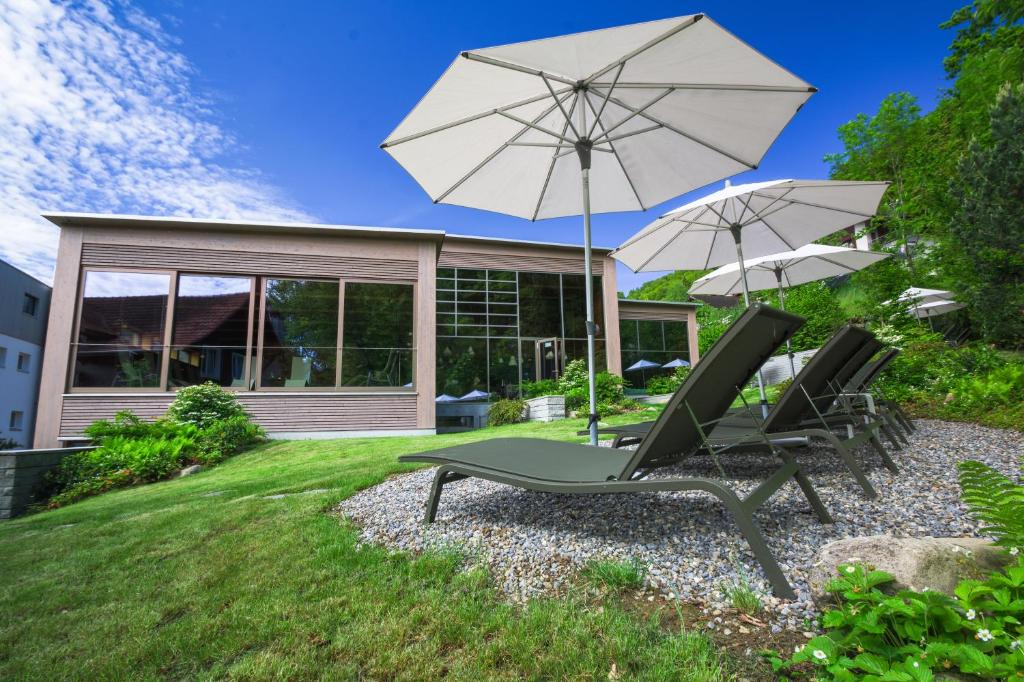 a patio with two chairs and an umbrella at Seehotel Wilerbad Spa & Seminar in Sarnen