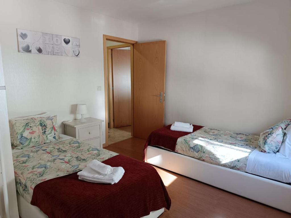 a room with two beds with towels on the bed sidx sidx sidx at Casinha Miradouro in Vila Nova de Gaia